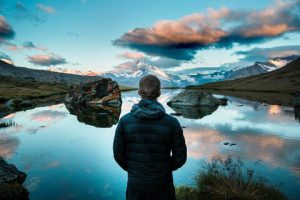 Standing alone looking over a lake