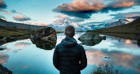Dream Big - A hiker looking out over a mountain lake