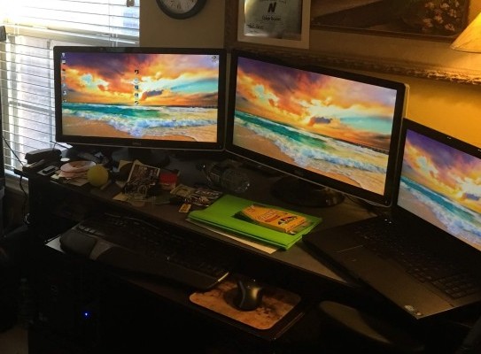 Home workstation with two large monitors and a laptop