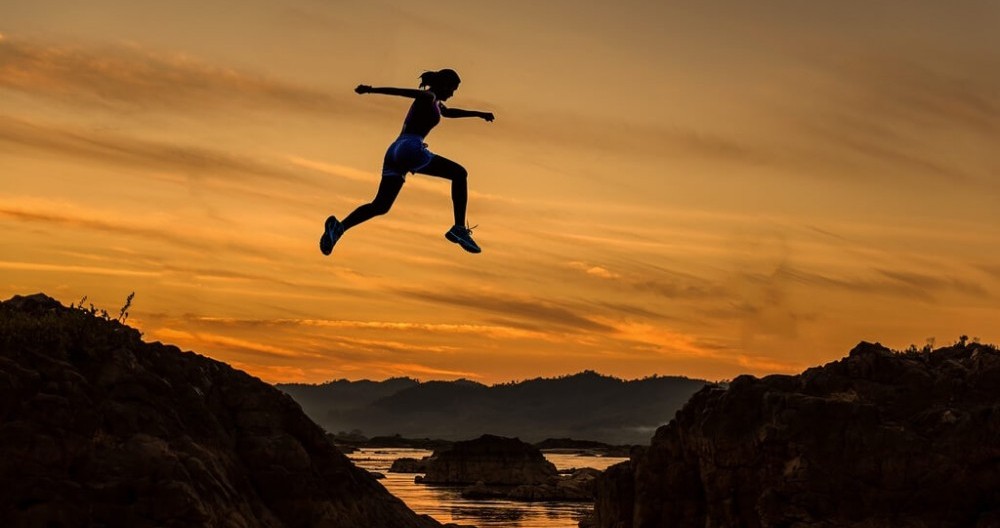 Keep the Dream Alive - woman jumping over a creek